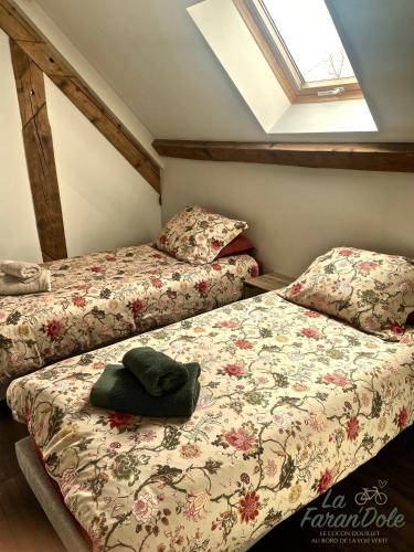 two beds in a small room with a window at La Faran'dole - Confortable duplex in Dole
