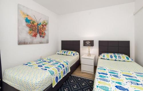 a bedroom with two beds and a painting on the wall at Villa Hemingway beachfront by Villas Guide in Velika Plana