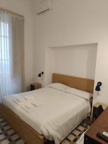 a bedroom with a large bed with white sheets at Residence e appartamenti Rosaroll in Naples