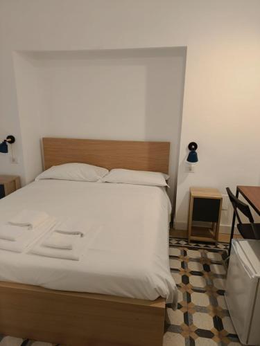 a bedroom with a large bed with white sheets at Residence e appartamenti Rosaroll in Naples
