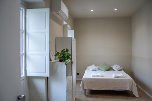 a small room with a bed and a refrigerator at Top Rooms Torino in Turin