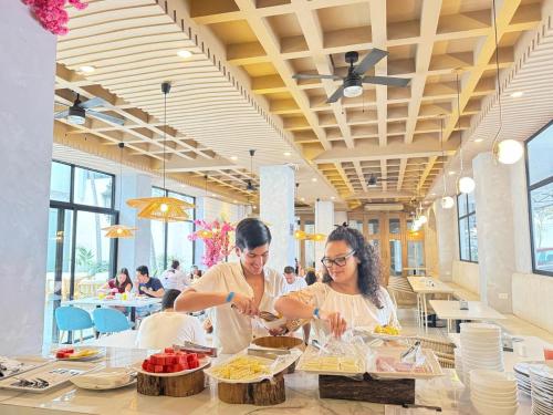 two women are preparing food in a restaurant at Hotel Presidente Beach Salinas in Salinas