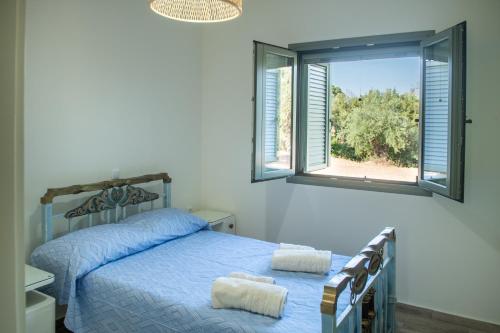 ein Schlafzimmer mit einem Bett, auf dem zwei Handtücher liegen in der Unterkunft Olive Coast Houses in Kyparissia