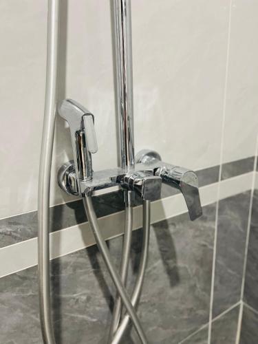 a shower attachment in a bathroom with a glass door at Tea Hotel by Chien Hao in Ha Giang