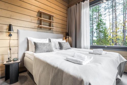 a bedroom with a large white bed with a window at Levin Lyhty Bianca by Hilla Villas in Levi