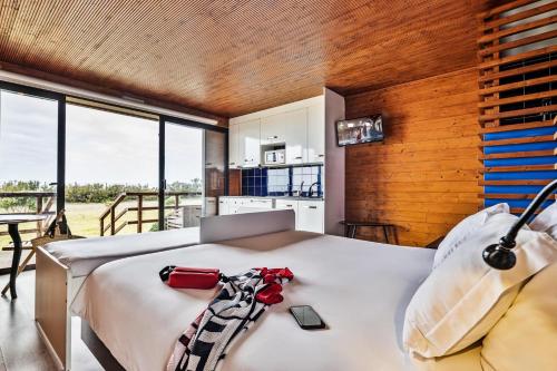 a bedroom with a bed with a laptop on it at PenichePraia - Bungalows, Campers & SPA in Peniche