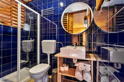 a blue tiled bathroom with a toilet and a sink at PenichePraia - Bungalows, Campers & SPA in Peniche