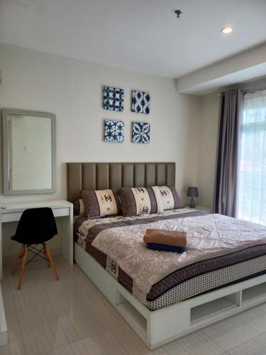 StalkudoにあるPENTAPOLIS WONGKITO APARTMENT di pusat kota Balikpapanのベッドと机と窓のある寝室