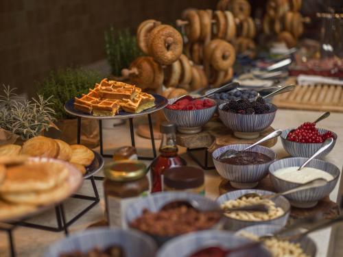 uma mesa cheia de diferentes tipos de pães e doces em Falkensteiner Resort Lake Garda em Salò