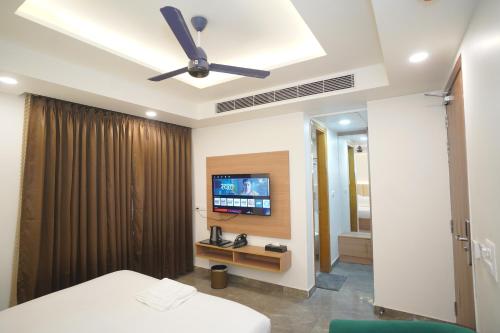 a bedroom with a ceiling fan and a television at Royal Raven Hotel & Banquet' Greater Noida Nearby India Expo Centre & Mart in Greater Noida