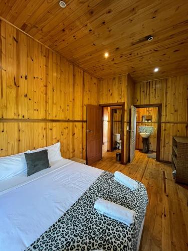 a bedroom with a bed in a room with wooden walls at Onda Azul Main House in Ponta do Ouro