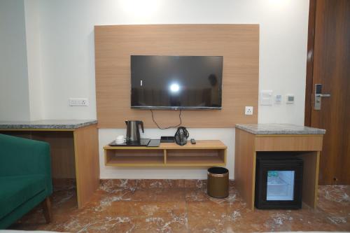 a room with a tv on a wall with a fireplace at Royal Raven Hotel & Banquet' Greater Noida in Greater Noida