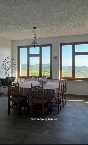 a dining room with a table and chairs and windows at Alla Torre Antica in Ruttàrs