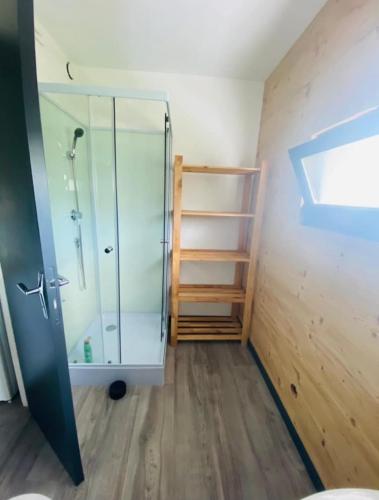 a bathroom with a glass shower and a wooden floor at Studio à Gérardmer, les Dryades in Gérardmer