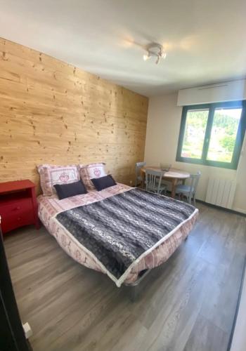 a bedroom with a bed and a wooden wall at Studio à Gérardmer, les Dryades in Gérardmer