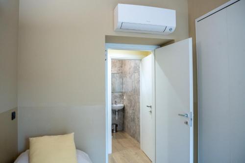 a room with a bed and a air conditioner on the ceiling at Top Rooms Torino in Turin