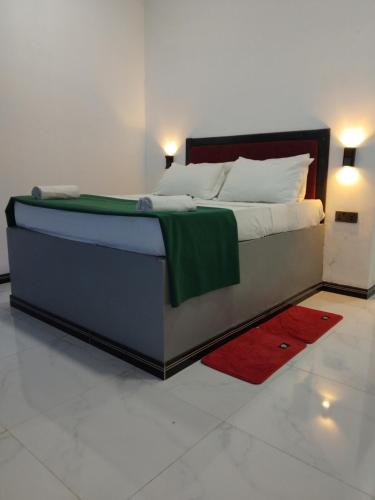 a bedroom with a large bed with a red rug at Ravan Pine Nature Retreat in Ella