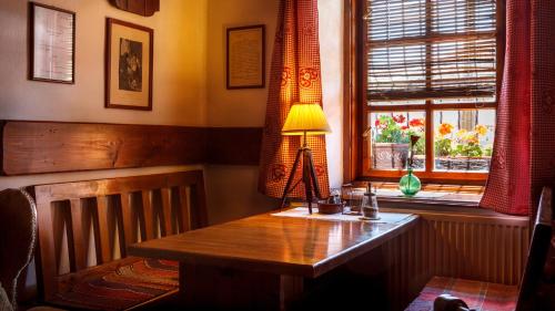 a room with a wooden table with a lamp on it at Penzion Barborka in Poprad