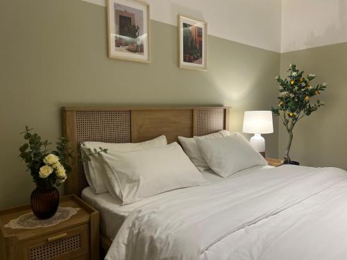 a bed with white sheets and pillows in a bedroom at بوتيك هاوس بدخول ذاتي وصالة أنيقة in Hail