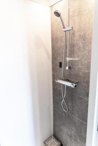 a shower with a shower head in a bathroom at Toftenäs gästhus in Toftenäs