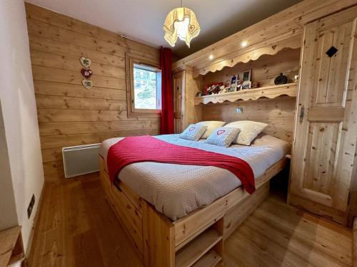 ein Schlafzimmer mit einem Bett in einer Blockhütte in der Unterkunft Appartement 3 pièces avec garage, terrasse, proche pistes et commerces à Arâches-la-Frasse - FR-1-572-250 in Arâches-la-Frasse