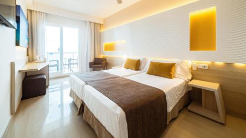 a hotel room with a large bed and a window at Globales Almirante Farragut in Cala en Blanes