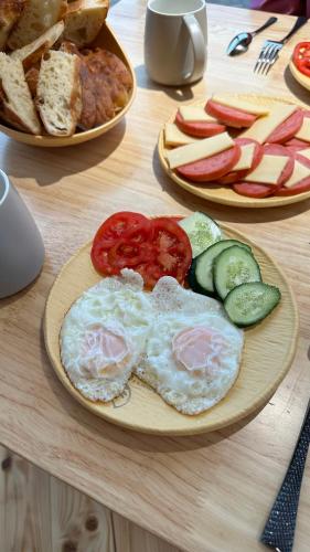 Kolsay and Kaiyndy lakes COZYREST في Saty: طاولة عليها أطباق من البيض والتفاح والخبز