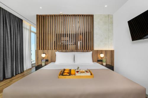 sypialnia z dużym łóżkiem i tacą z jedzeniem na nim w obiekcie Pefka Hotel w Salonikach