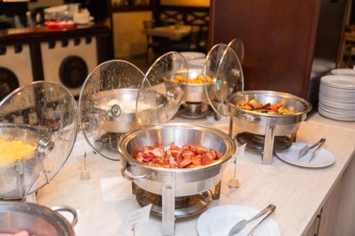 a buffet with four bowls of food on a table at Kopernikus Hotel Prag in Belgrade