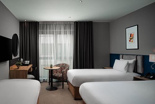 a hotel room with two beds and a table at George Limerick Hotel in Limerick