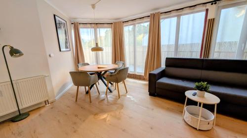 ein Wohnzimmer mit einer Couch und einem Tisch und Stühlen in der Unterkunft CASA BENJI Dohma - geräumige FeWo - Familien - Parkplatz - Waschmaschine in Dohma