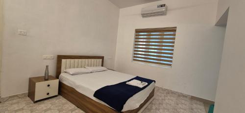 a small bedroom with a bed and a window at Nest&Nook in Ettumānūr