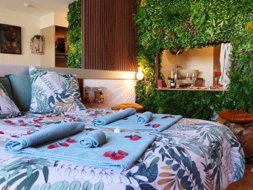 a bed with blankets and pillows on top of it at Romance&Tentation-Balnéo 2 places in Carquefou