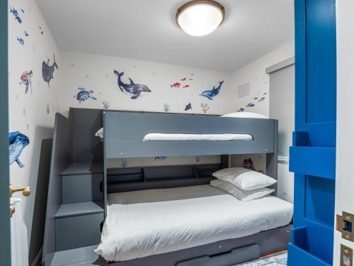 a childs bedroom with a blue bunk bed at 2 Harbour View in Roundstone