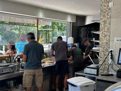 a group of people preparing food in a kitchen at Camping Les Pins de la Coubre in Les Mathes