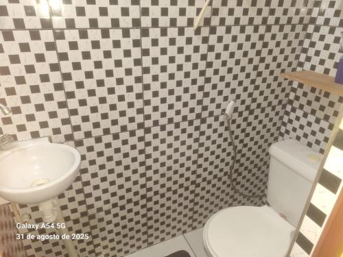 a bathroom with a white toilet and a sink at Casa de Praia in Mosqueiro