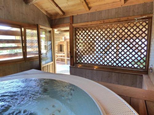 eine Whirlpool-Badewanne auf der Rückseite eines Hauses in der Unterkunft Charmant 3 pièces rénové avec sauna et jacuzzi pour 6 pers. au Grand-Bornand - FR-1-458-107 in Le Grand-Bornand