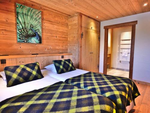 ein Schlafzimmer mit einem Bett in einer Holzwand in der Unterkunft Charmant 3 pièces rénové avec sauna et jacuzzi pour 6 pers. au Grand-Bornand - FR-1-458-107 in Le Grand-Bornand
