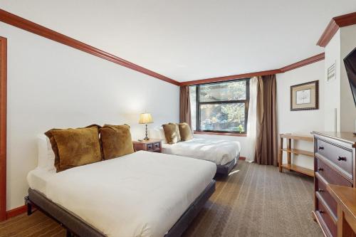a hotel room with two beds and a window at Everline Resort & Spa 317 in Olympic Valley