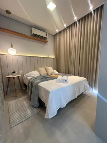 a bedroom with a bed with two towels on it at Plaza Mayor Loft in Capão da Canoa
