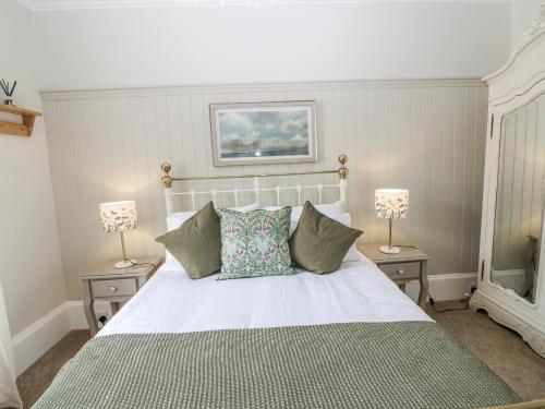 a bedroom with a large white bed with two lamps at 11A High Street in Jedburgh