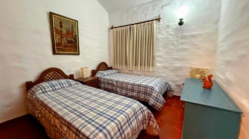 a room with two beds and a desk and a window at Casa Panoramica Maria Ines in Villa Carlos Paz