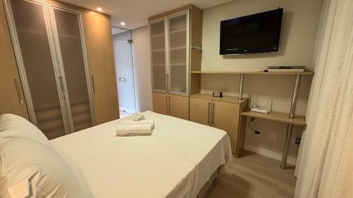 a hotel room with a bed and a television at Bahamas 357 - Com Garagem Coberta Gratúita in Águas Claras