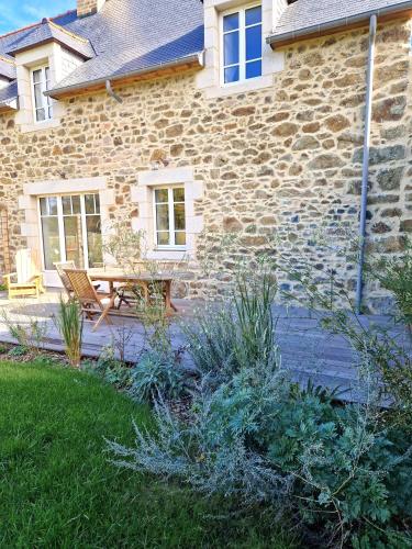 a stone house with a table and bench in the yard at Maison de vacances site exceptionnel - in außergewöhnlicher Lage in Pléneuf-Val-André