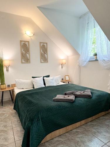 a bedroom with two beds with a green blanket at Szent Kristóf Panzió in Eger