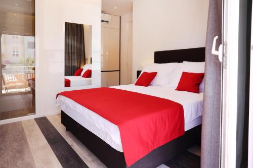 a bedroom with a large bed with a red blanket at Villa M in Split
