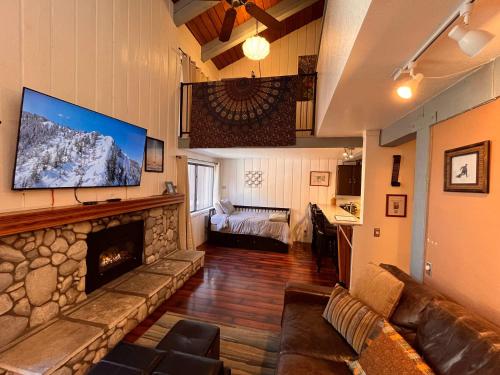 Una sala de estar con un sofá y una chimenea. en Cozy Studio with Loft at Mammoth Ski & Racquet Club, Hot Tub, Garage, 10 Min Walk to Ski Lifts, en Mammoth Lakes