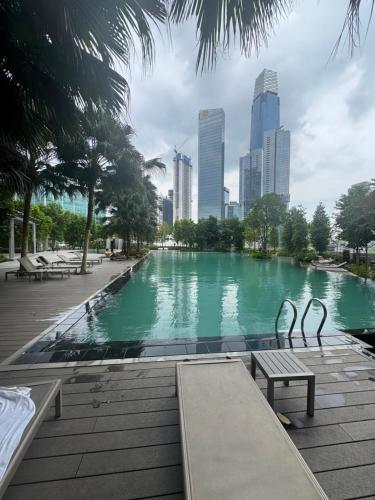 a swimming pool with benches and a city in the background at KLCC Agile Sky villa Residences in Kuala Lumpur