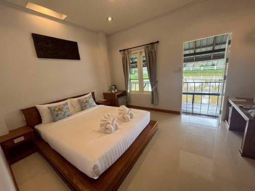 Un dormitorio con una cama con dos toallas encima. en Kenikar Raintree Residence Hotel, en Chumphon