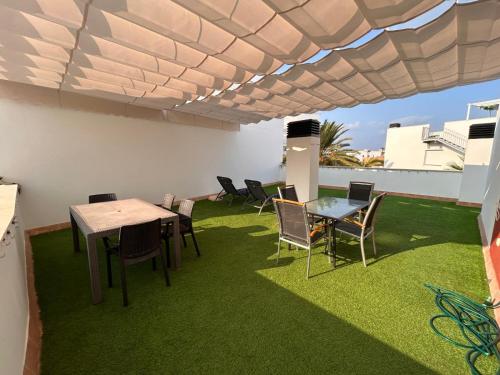 a room with a table and chairs on a roof at Apartamento "Casa el Sargazo" en Vera Playa con Piscina, Solarium, Wifi y Parking Gratis in Vera